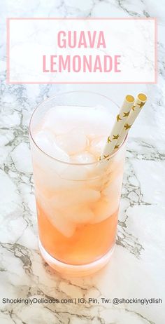 a glass filled with liquid sitting on top of a marble counter next to a straw