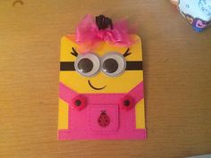 a yellow and pink minion card holder on a table