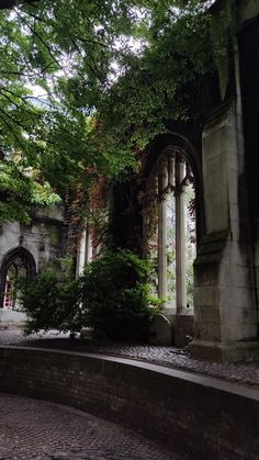 an old building with trees growing out of it's sides and stone walkways