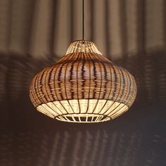 a light that is hanging from a ceiling in a room with shadows on the wall