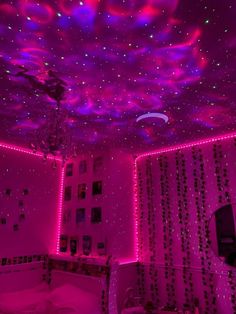 a bedroom with pink lights and stars on the ceiling is lit up in purple hues