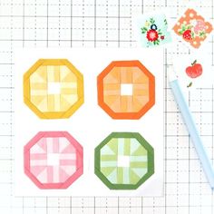 the four pieces of quilting are laid out on a cutting board next to a pencil