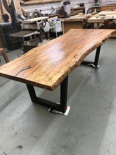 a large wooden table sitting in a room next to other woodworking tools and equipment