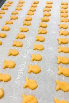 the cookies are ready to be baked and decorated with yellow icing on a baking sheet