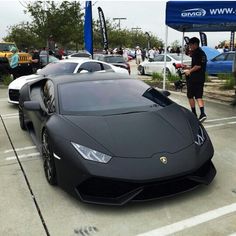 a man standing next to a gray sports car