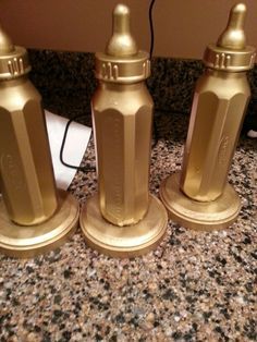 three golden salt and pepper shakers sitting on top of a counter