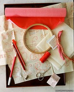 crafting supplies laid out on top of a wooden tray with thread, scissors and other items