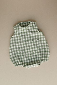 Product photos - green gingham. The model is wearing a romper in yellow gingham. Made from 100% linen, Lucy baby romper is designed to feel light and comfortable. No matter how much your little one wiggles throughout the day, the romper will stay in place thanks to elasticized cuffs on the legs and popper snap fastenings that make changing effortless. Featuring a cute chest pocket in the middle to complete a cheerful look. For any occasion or any big adventure. This baby romper is designed to be comfortably loose-fitting and allow for growth as the baby grows. Playful Gingham Bubble Romper For Spring, Cute Green Cotton Bubble Romper, Plaid Cotton Bubble Romper For Summer, Summer Cotton Plaid Bubble Romper, Summer Plaid Cotton Bubble Romper, Summer Gingham Cotton Bubble Romper, Playful Green Cotton Jumpsuits And Rompers, Playful Gingham Cotton Bubble Romper, Cute Summer Bubble Romper With Pockets