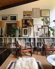 a living room filled with lots of furniture and pictures on the wall above it's bookshelf