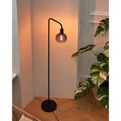 a lamp that is on top of a wooden table next to a potted plant