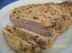 a white plate topped with sliced meat on top of a blue tablecloth covered table