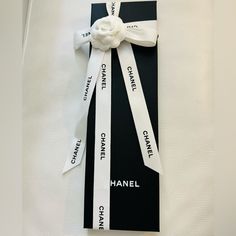 a black and white box with a ribbon around it that says chanel on the side