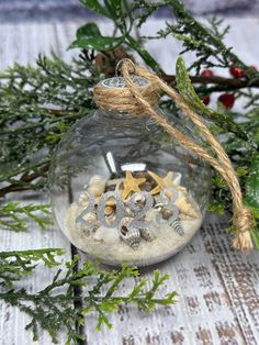 a glass ornament filled with sand and shells