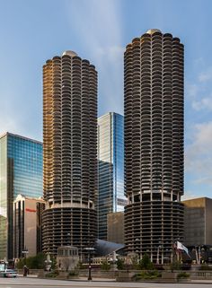 two tall buildings are next to each other in front of the city's skyscrapers