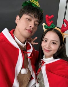 a man and woman dressed up in christmas costumes posing for a photo with reindeer antlers on their heads