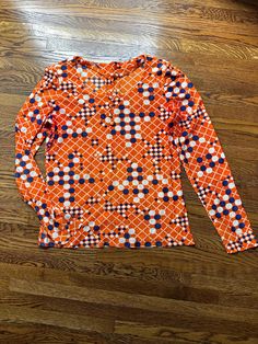 This vintage 1970's blouse had a geometric design in orange blue and some white.  It has long sleeves with 3 faux buttons on each sleeve and on center of the scoop neckline. It is slinky feeling material. It is in great condition. It is a size small. Chest-35 inches Waist-31 inches Hem-36 inches around Sleeve-24 inches Shoulder to shoulder seam-14 inches To see more of our authentic 1970's clothing inventory please visit our store at ChoiceRecycling.  We add new items every week.  Thank you, Karmyn Blue Long Sleeve Top With Geometric Pattern, Retro Orange Tops For Fall, Blue Long Sleeve Tops With Retro Print, Orange Long Sleeve Tops With Graphic Print, Orange Long Sleeve Top With Graphic Print, Blue Long Sleeve Top With Retro Print, Orange Long Sleeve Printed Tops, Orange Printed Long Sleeve Tops, Retro Orange Long Sleeve Blouse