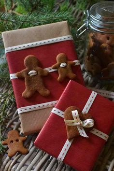 two wrapped presents sitting on top of a wicker basket next to a jar filled with cookies