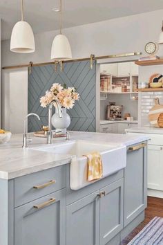 a kitchen with blue cabinets, white counter tops and yellow accents on the wall above the sink