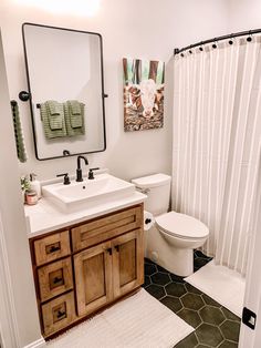 a bathroom with a toilet, sink and shower curtain in it's center area