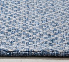 a blue and white rug on the floor with small holes in it's center