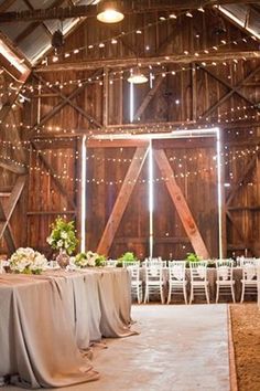 an image of a barn with tables and chairs set up for a wedding reception at night