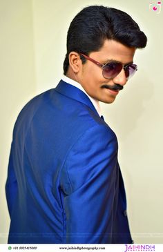 a man in a blue suit and sunglasses with a moustache on his face