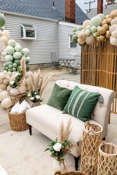 a couch sitting on top of a rug next to some baskets filled with flowers and balloons