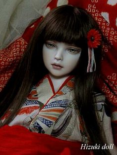 a doll with long brown hair wearing a kimono