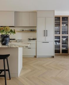 a kitchen with white cabinets and wooden floors