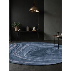 a round rug with blue and white swirls on it in a dark colored room