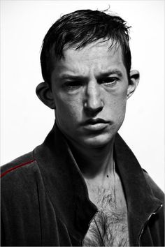 a black and white photo of a young man with an unkempt look on his face