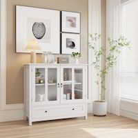 a white cabinet with glass doors in a room next to a window and potted plant