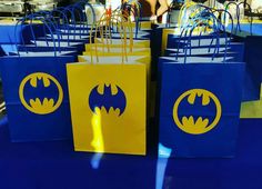 blue and yellow bags with batman logos on them are sitting on a table at a party