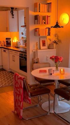 a kitchen with a table and chairs next to a stove top oven in the corner