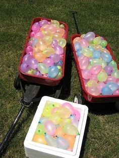 two carts filled with balloons sitting in the grass