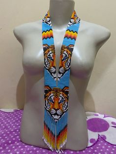 a white mannequin with a colorful tiger design on it's head and tassels