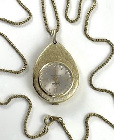 Vintage Watch Pendant MCM Sheffield This fabulous mid-century pendant watch is teardrop shaped and has a brushed texture gold tone finish. This wonderful Mid Century Modern watch has a wind up mechanism and was made by Sheffield in the 1960s. The face is round and white with gold numeral markers it is marked Sheffield and shockprotected and swiss made. The back reads SWISS MADE 12224. When I tested this watch, it did run and kept accurate time for about 10 hours but then slowed down. This is a vintage watch and I am not a watch expert so I cannot guarantee that it will always run smoothly and keep accurate time. This pendant is suspended on a gold tone metalbox chain. Pendant measures 2 1/4" x 1 3/8" x 1/4" Chain measures 24" long. This piece is in good vintage condition but does show some Watch Pendant, Mid Century Pendant, Pendant Watch, Modern Watches, Pendant Watches, Gold Texture, Watch Necklace, Swiss Made, Sheffield