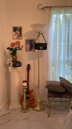 a living room filled with furniture and a guitar on top of a floor next to a window