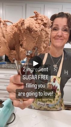 a woman is holding up two large chocolate ice creams in one hand and the other