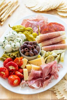 a white plate topped with lots of different types of meats and veggies