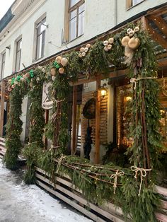 a store front decorated with christmas greenery and decorations