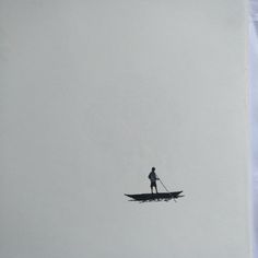 a man standing on top of a boat in the middle of foggy water with a paddle