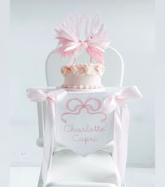 a pink cake sitting on top of a white chair