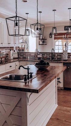 a large kitchen with an island in the middle and lots of lights hanging from the ceiling