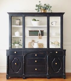 a black china cabinet with glass doors and drawers