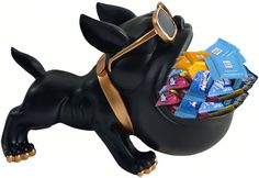 a black dog figurine with sunglasses and candy in it's mouth