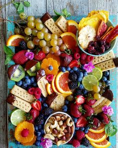 a platter filled with fruit, crackers and nuts