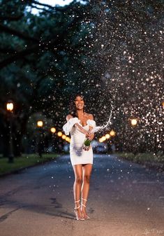 a woman standing in the middle of a street with snow falling all over her face