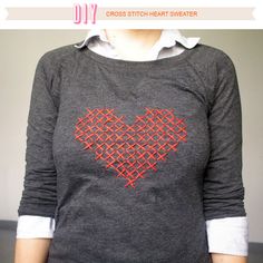 a woman wearing a gray shirt with a red heart on it