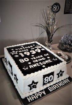 the birthday cake is decorated with black and white numbers, stars, and balloons for someone's 80th birthday